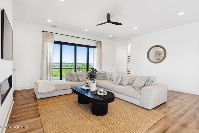 living room featuring ceiling fan and light hardwood / wood-style flooring