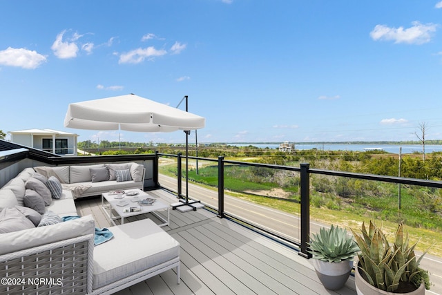 wooden terrace featuring an outdoor living space and a water view