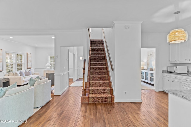 living room with ornamental molding and light wood-type flooring