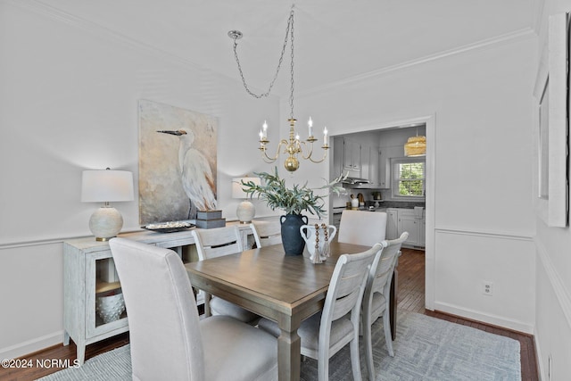 dining room with dark wood-type flooring, crown molding, and a chandelier