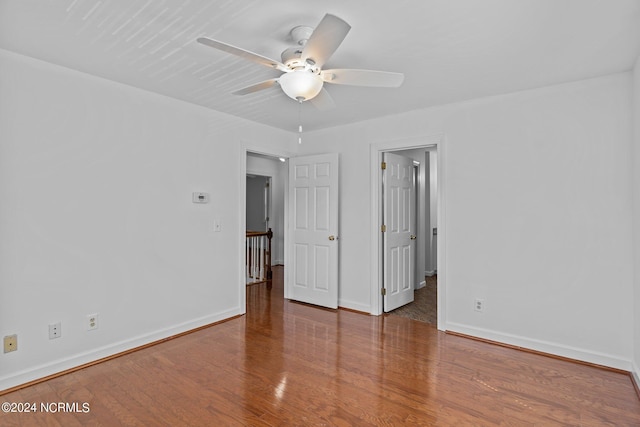 empty room with dark wood-type flooring and ceiling fan