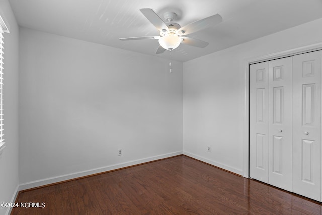 unfurnished bedroom with dark hardwood / wood-style floors, a closet, and ceiling fan