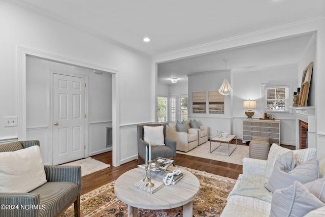 living room featuring hardwood / wood-style flooring, a fireplace, and crown molding