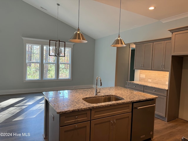 kitchen featuring dishwasher, sink, vaulted ceiling, dark hardwood / wood-style floors, and light stone counters