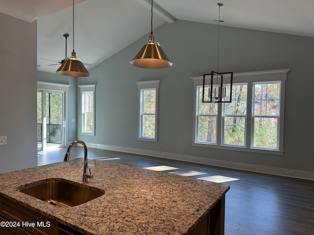 kitchen featuring dark wood-type flooring, high vaulted ceiling, sink, light stone countertops, and decorative light fixtures