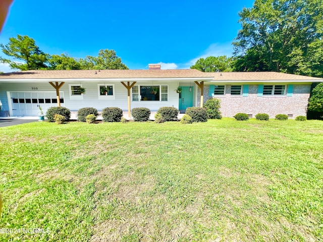 single story home featuring an attached garage, brick siding, driveway, a front lawn, and a chimney