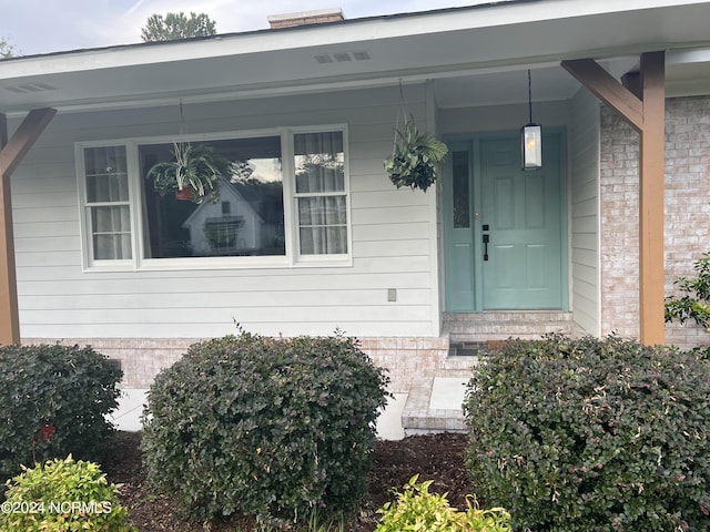 doorway to property featuring brick siding