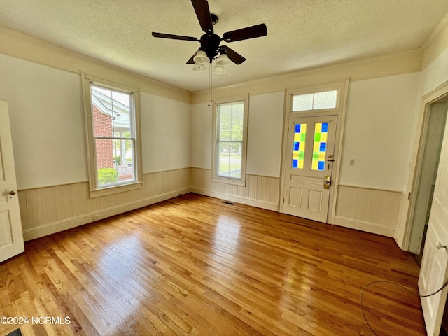 unfurnished room featuring light hardwood / wood-style floors, a textured ceiling, and ceiling fan