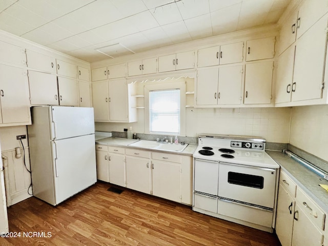 kitchen featuring sink, white appliances, hardwood / wood-style floors, and white cabinetry