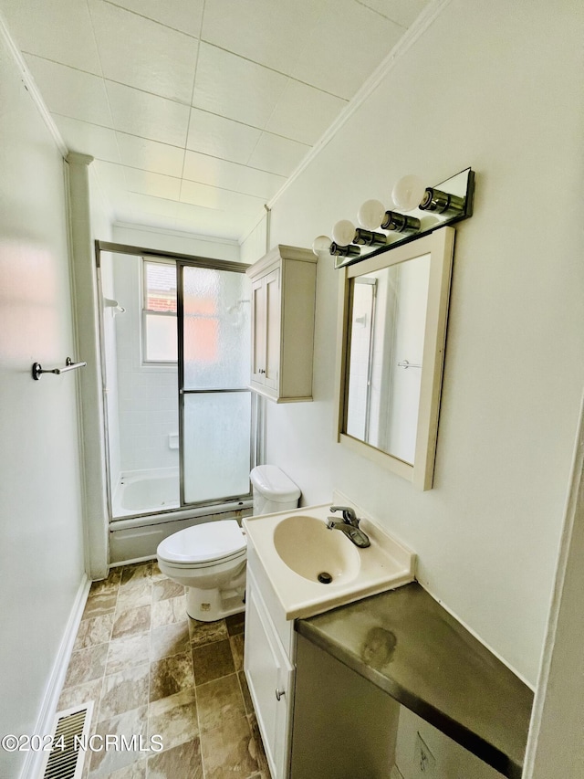 full bathroom featuring tile patterned flooring, bath / shower combo with glass door, crown molding, toilet, and vanity