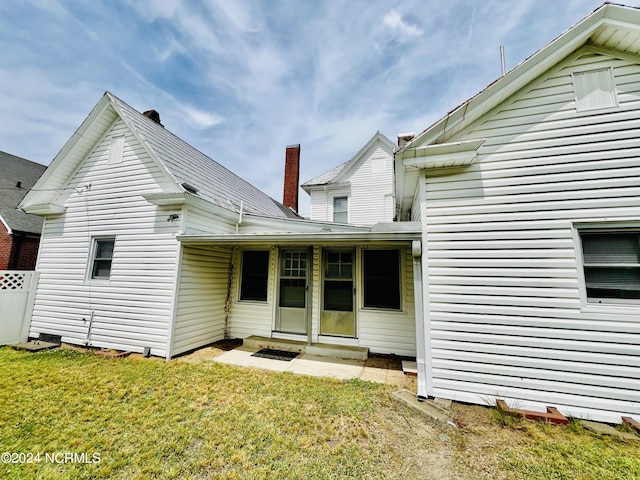 rear view of property with a lawn