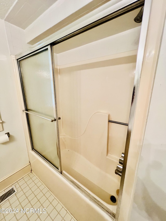 bathroom featuring shower / bath combination with glass door and tile patterned floors