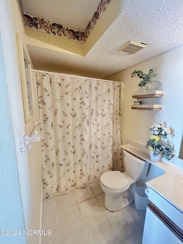 bathroom featuring a textured ceiling, toilet, vanity, visible vents, and tile patterned floors