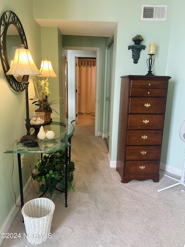 hall featuring carpet flooring, visible vents, and baseboards