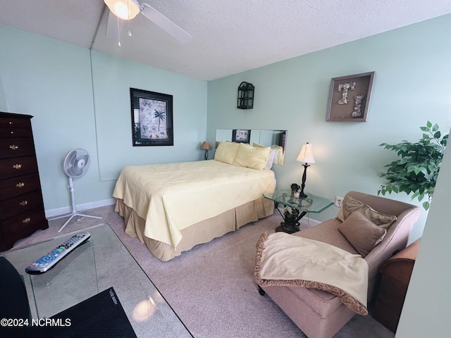 bedroom with a textured ceiling, ceiling fan, and carpet