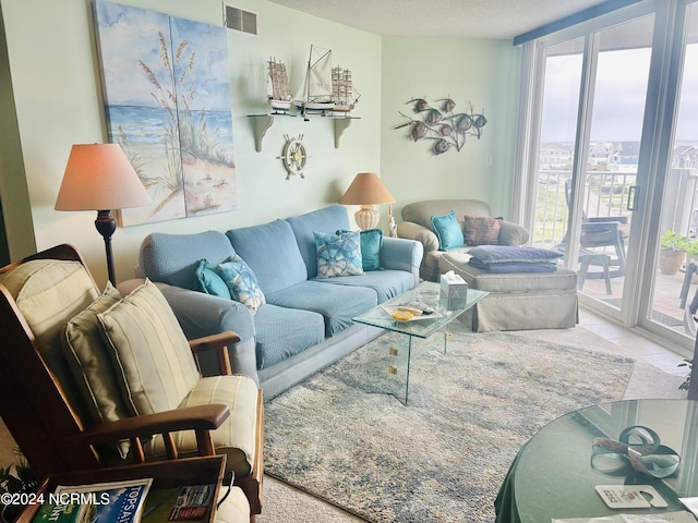 living room featuring tile patterned flooring, visible vents, and a textured ceiling