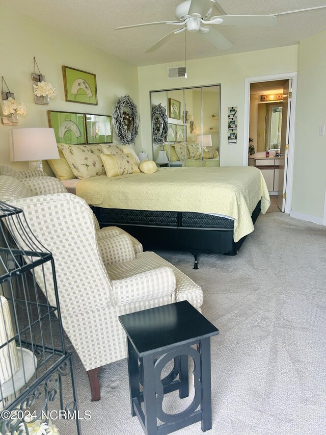 carpeted bedroom featuring connected bathroom, visible vents, and ceiling fan