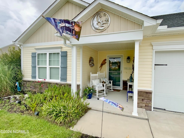 property entrance with covered porch and a garage