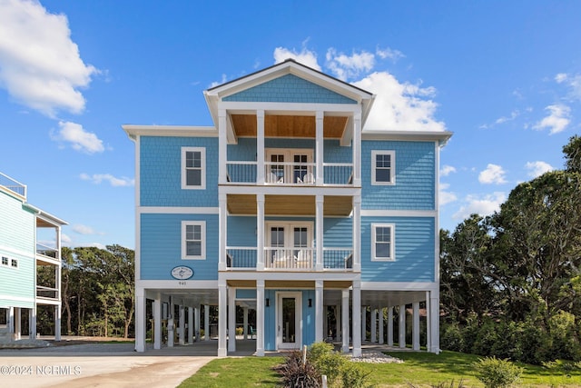 coastal home featuring a balcony and a carport