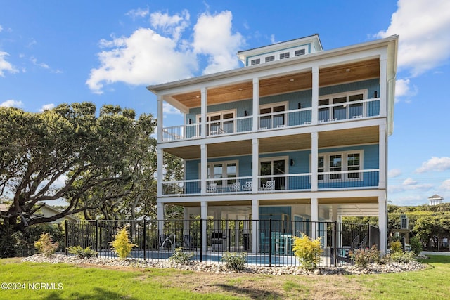 rear view of property featuring a balcony and a pool