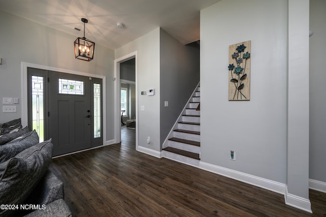 entrance foyer with dark hardwood / wood-style flooring and a notable chandelier