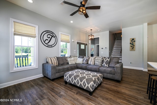 living room featuring ceiling fan with notable chandelier and dark hardwood / wood-style floors