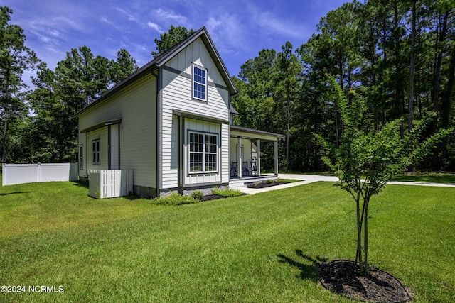 back of house with a porch, cooling unit, and a lawn