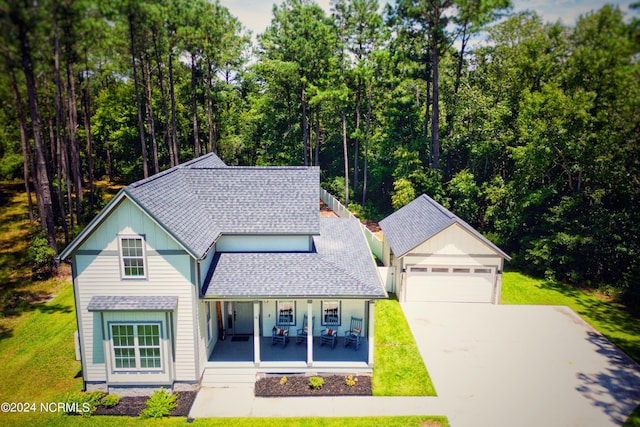 front facade with a garage, a front yard, and a porch