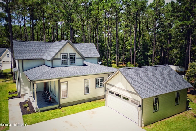 view of front facade featuring a front yard, a garage, and a porch