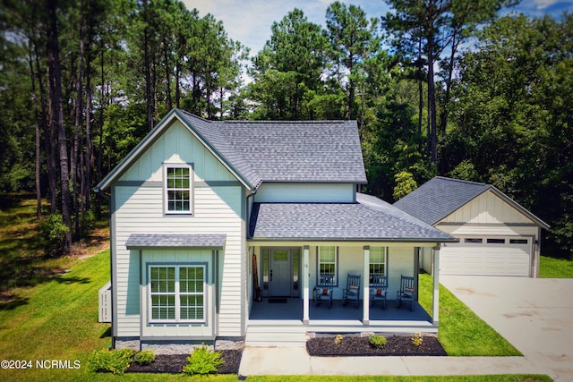 view of front of property with a front lawn, a garage, and a porch