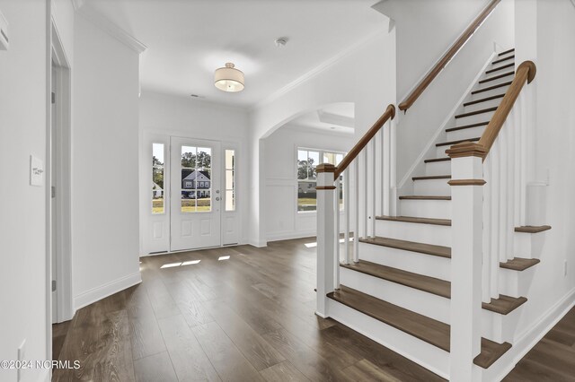 65 Tilloo Cut Way, Hampstead, NC 28443 - entryway with arched walkways, dark wood-style flooring, stairway, baseboards, and crown molding