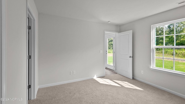 carpeted empty room featuring a wealth of natural light