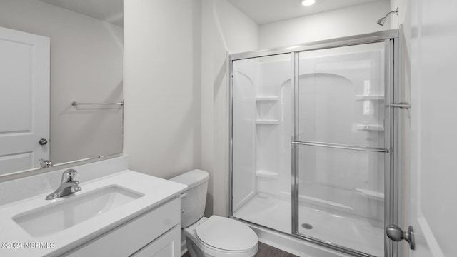 bathroom with vanity, toilet, and an enclosed shower