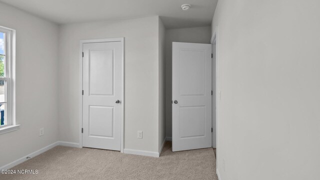 unfurnished bedroom with light carpet