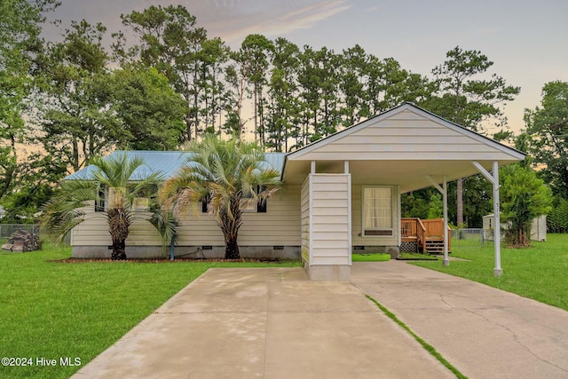 view of front facade featuring a carport and a lawn