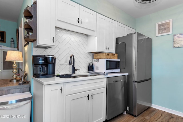 kitchen featuring tasteful backsplash, stainless steel appliances, white cabinets, sink, and dark hardwood / wood-style floors