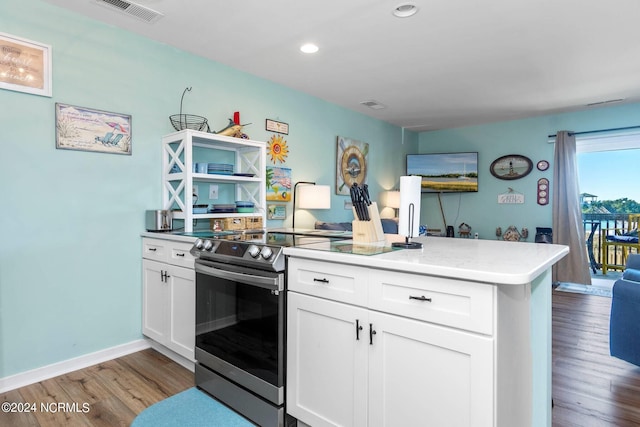 kitchen with kitchen peninsula, light hardwood / wood-style flooring, white cabinets, and stainless steel electric range