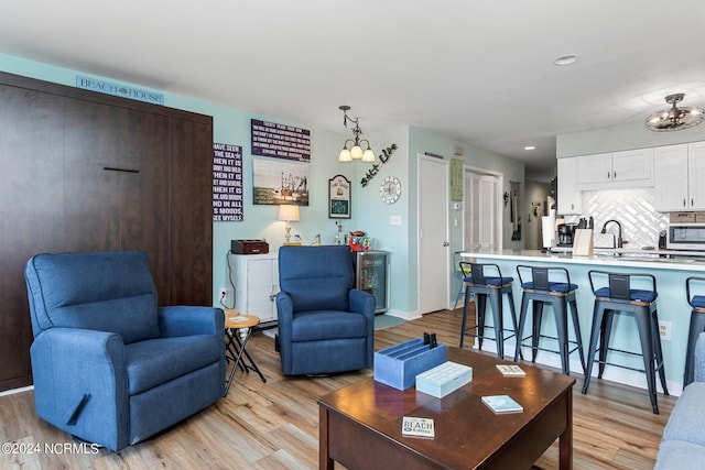 living room with a notable chandelier and light hardwood / wood-style floors