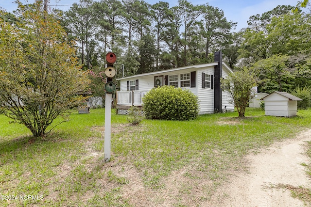 view of front of house featuring an outbuilding and a front yard