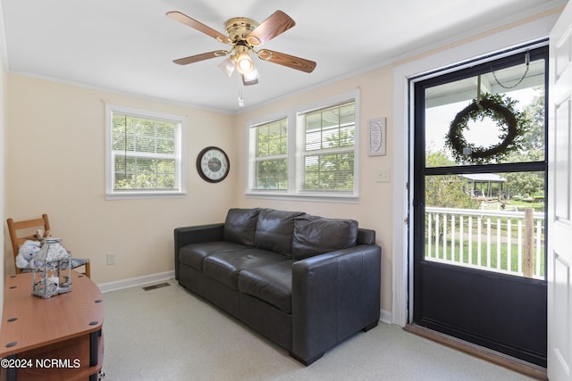 living room with carpet flooring, ceiling fan, plenty of natural light, and crown molding