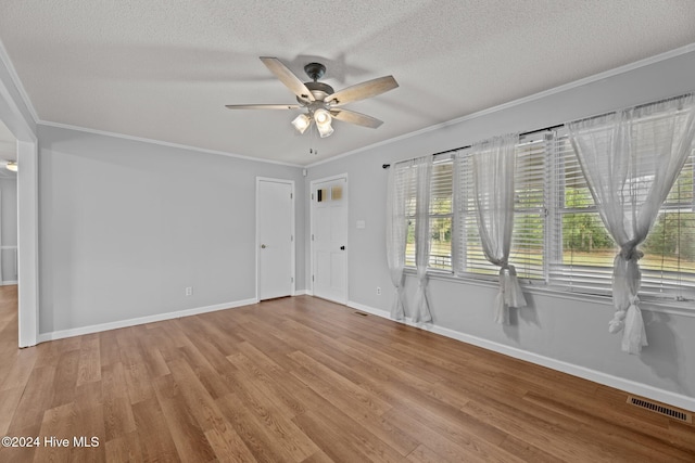 spare room featuring ornamental molding, wood finished floors, visible vents, and baseboards