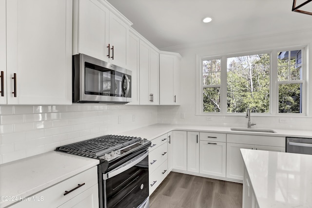 133 Tilloo Cut Way, Hampstead, NC 28443 - kitchen with stainless steel appliances, a sink, white cabinets, decorative backsplash, and recessed lighting