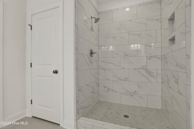 bathroom featuring tile patterned flooring and tiled shower