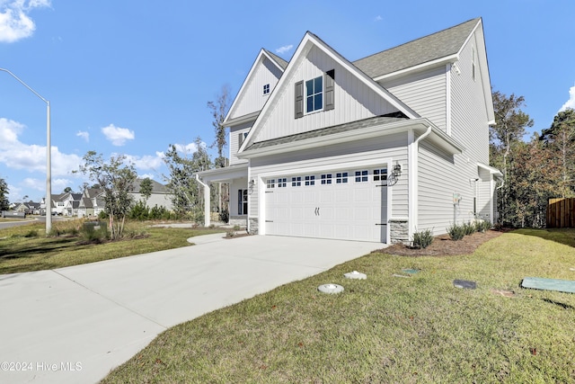 133 Tilloo Cut Way, Hampstead, NC 28443 - view of side of home with concrete driveway, board and batten siding, a yard, stone siding, and a garage
