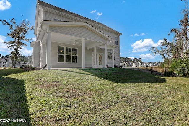 back of property featuring a lawn and ceiling fan