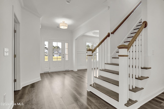 133 Tilloo Cut Way, Hampstead, NC 28443 - foyer featuring arched walkways, dark wood-style floors, stairway, ornamental molding, and baseboards