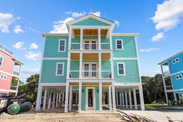 beach home featuring a carport, driveway, and a balcony