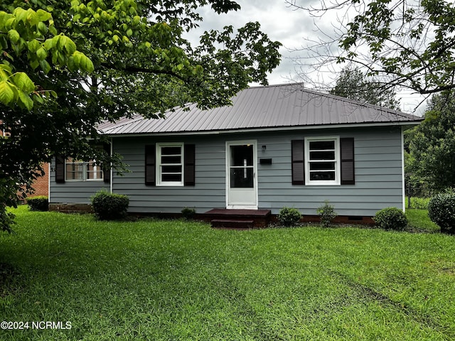 ranch-style house featuring metal roof, crawl space, and a front yard