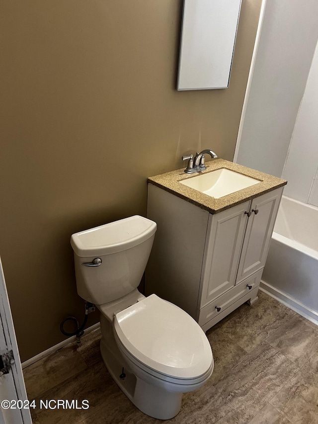 bathroom featuring wood finished floors, vanity, and toilet