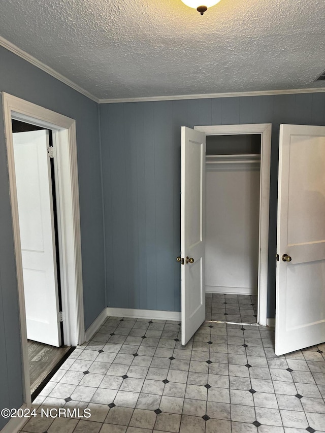 unfurnished bedroom featuring ornamental molding, a closet, and a textured ceiling